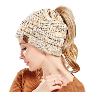 Detail of multi-color confetti knit beanie with high ponytail opening and leather label