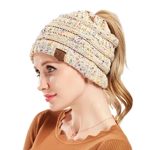 Detail of off-white knit ponytail beanie featuring colorful flecks and a C.C leather patch