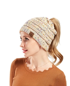 Detail of chunky knit ponytail beanie in beige marl yarn with CC leather brand label