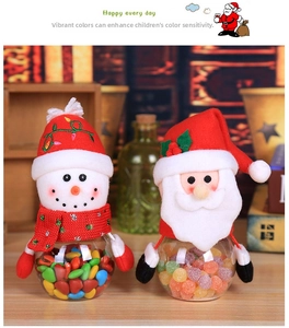 Detail of Christmas candy jars with plush Santa and Snowman toppers and clear gift containers