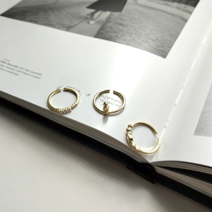 Detailed view of three stackable gold rings featuring sparkling zircons and geometric designs