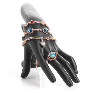 Rose gold jewelry set with colorful gemstones displayed on a black hand mannequin