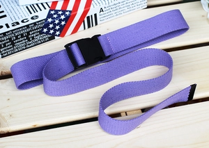Detail showing purple canvas belt texture and black plastic buckle on wooden background