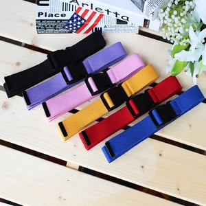 Multicolor canvas belts with plastic buckles for women, shown in a lifestyle flat lay