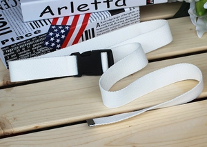 Close-up of white woven canvas tactical belt with a durable black plastic quick-release buckle