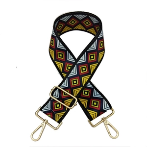 Close-up of adjustable nylon bag strap with colorful geometric patterns and gold metal hooks