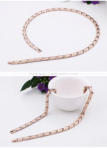 Detail of rose gold magnetic therapy jewelry set draped on white ceramic cup for display