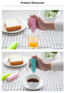 Handheld electric milk frother in pink and green shown mixing coffee and juice
