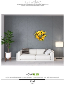 Close-up of artificial sunflower wreath with green leaves and a yellow polka dot bow on wall