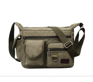 Detail view of army green canvas crossbody bag featuring functional pockets and metal hardware