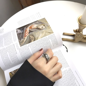 Detail of vintage 925 sterling silver multi-layer braided ring on an artistic book