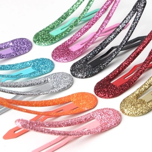 Détail de barrettes à cheveux pailletées colorées aux nuances variées sur fond blanc
