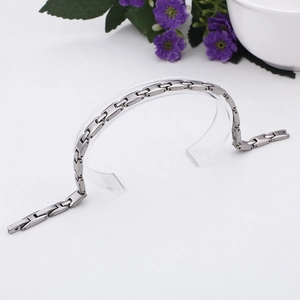 Sleek silver H-link chain bracelet in titanium steel displayed on a clear jewelry stand