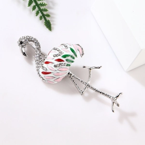 Close-up of pink and white flamingo brooch with sparkling rhinestones and enamel wings