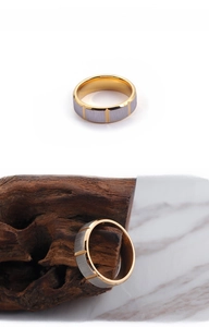 Detail of two-tone titanium ring with brushed grey surface and gold grooves