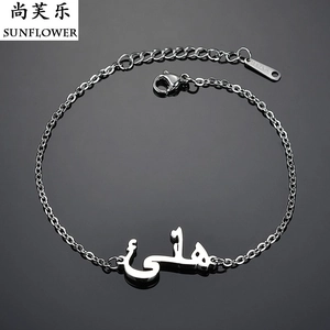 Macro shot of silver stainless steel chain bracelet with engraved Arabic text and lobster clasp
