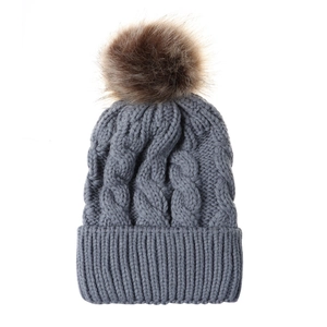 Grey cable knit winter hat with a fluffy faux fur pompom and wide ribbed cuff