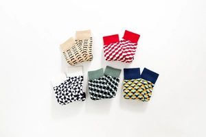 Flat lay of five pairs of colorful cotton socks with geometric patterns and mustache designs