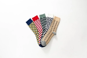 Flat lay of five pairs of colorful cotton socks with vibrant patterns on white background