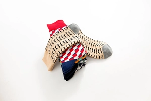 Close-up of stacked colorful cotton crew socks featuring diverse geometric patterns