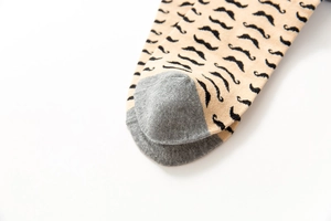 Close-up of cotton sock with black mustache pattern and contrast gray toe detail