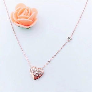 Detail view of rose gold heart pendant with crystal inlay on a delicate O-chain