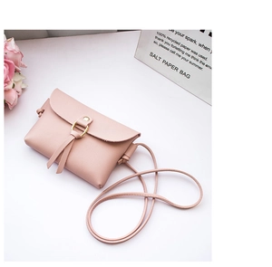 Detail of pink mini crossbody bag with gold metal ring and leather tassel decoration