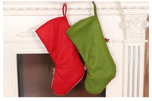 Gros plan de chaussettes de Noël rouges et vertes suspendues à un manteau de cheminée blanc