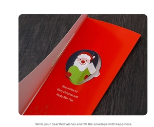Close-up of red 3D Christmas card with Santa illustration on dark wood background