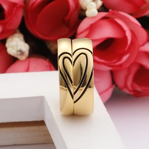 Polished gold couples' rings featuring a matching black heart design on stainless steel