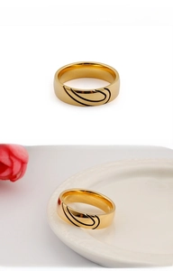 Close-up of gold titanium steel heart ring with black wave enamel pattern and polished finish