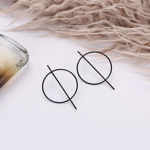 Macro detail of black geometric resin earrings with a minimalist circular design