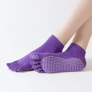 Calze da yoga viola a cinque dita con gommini antiscivolo per donna su sfondo bianco