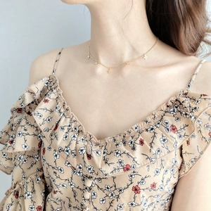 Close-up of model wearing 925 sterling silver golden mini cross pendant necklace