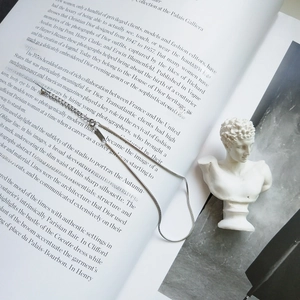 Elegant S925 sterling silver snake chain anklet displayed on a vintage book