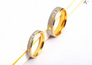 Macro shot of 18K gold plated couple rings with forever love engraving and small zircons
