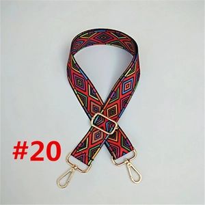 Detail of red geometric diamond pattern woven bag strap with golden metal swivel hooks