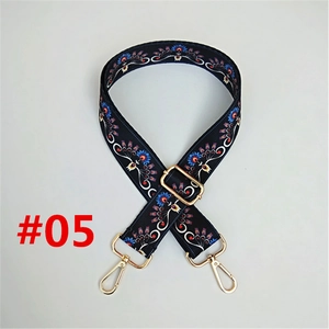 Close-up of adjustable ethnic floral bag strap with gold metal hooks and colorful embroidery