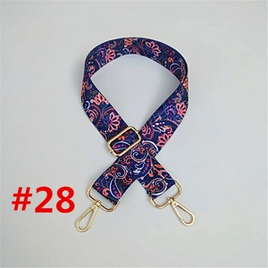 Close-up of ethnic style navy blue replacement bag strap with pink floral weave and gold hooks