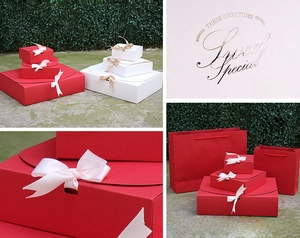Detail of red gift box with cream bow and golden text printing for cosmetics packaging