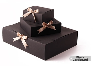 Three-tier black cardboard gift boxes with champagne silk bows in vertical stack