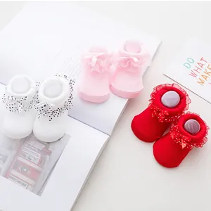 Detailed view of baby lace cotton socks in white, pink, and red with polka dot bows