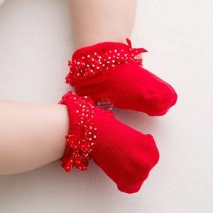 Close-up of red cotton baby socks featuring white polka dot lace and bow decoration