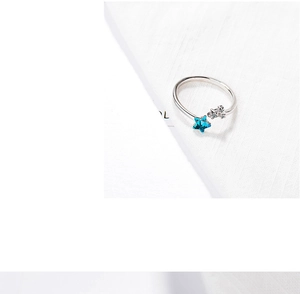 Macro shot of silver adjustable ring featuring blue star and sparkling crystal stars