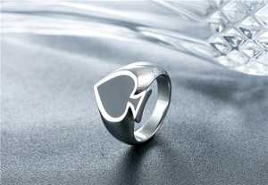 Macro shot of silver titanium ring featuring a black spade emblem on a textured surface