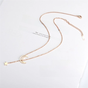 Detailed close-up of rose gold star and moon pendant with real gold plating finish