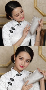 Detail der silbernen gewebten Clutch mit Diamanten, gehalten von Model im weißen Cheongsam
