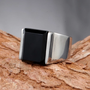 Détail d'une bague gothique punk pour hommes avec pierre noire sur écorce rustique