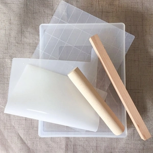Detail of DIY snowflake cake mold set featuring wooden rolling pins and acrylic grid plate