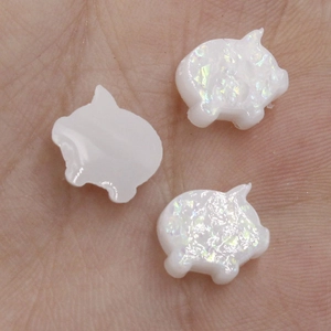 Macro shot of 11x10.3mm pig-shaped synthetic opal beads with glitter for DIY jewelry